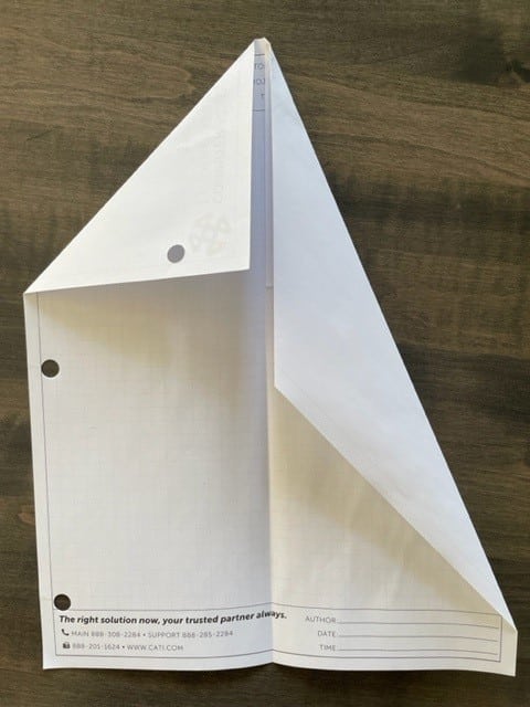 A white piece of paper on a wooden surface Description automatically generated with low confidence